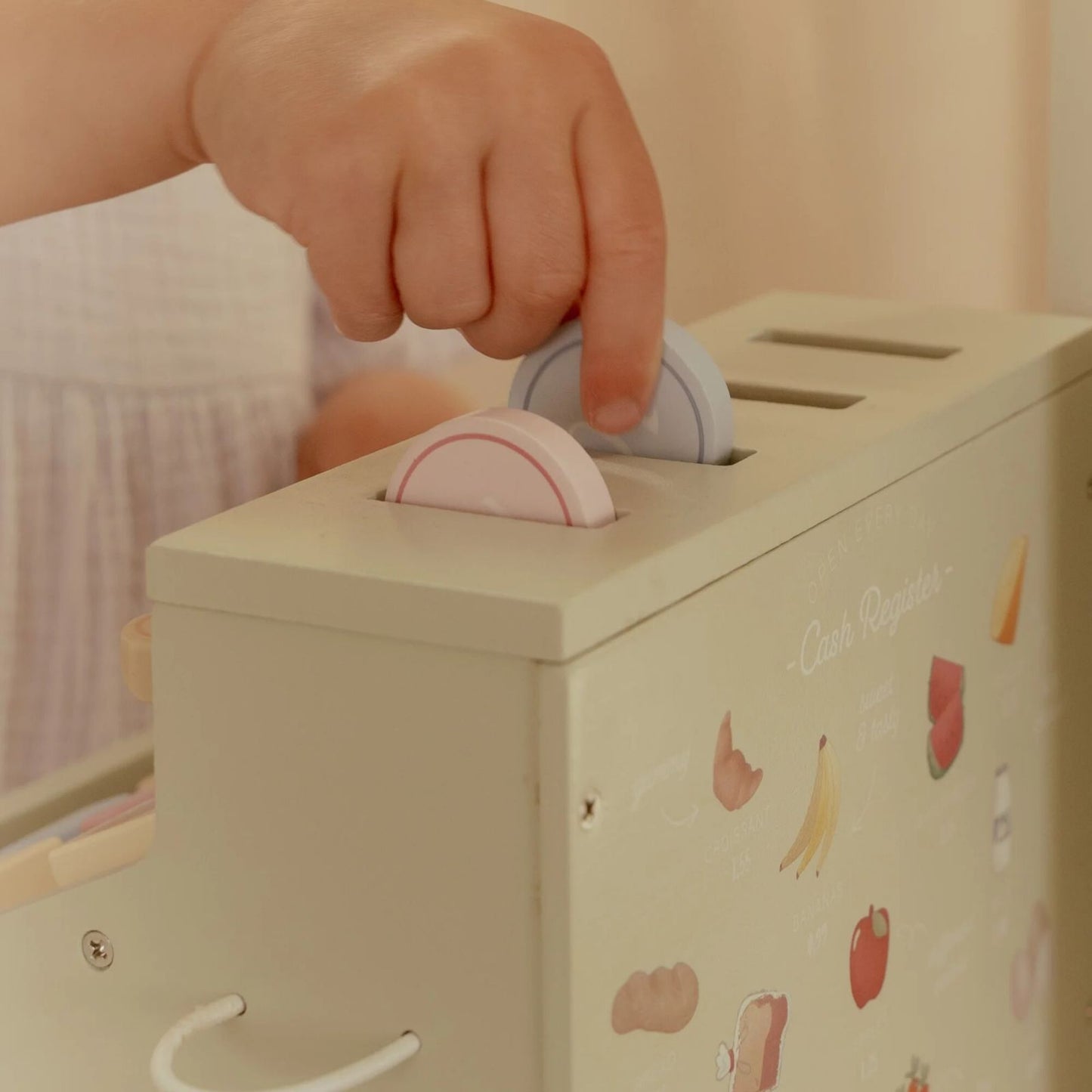 bimba che gioca con monete e registratore di cassa