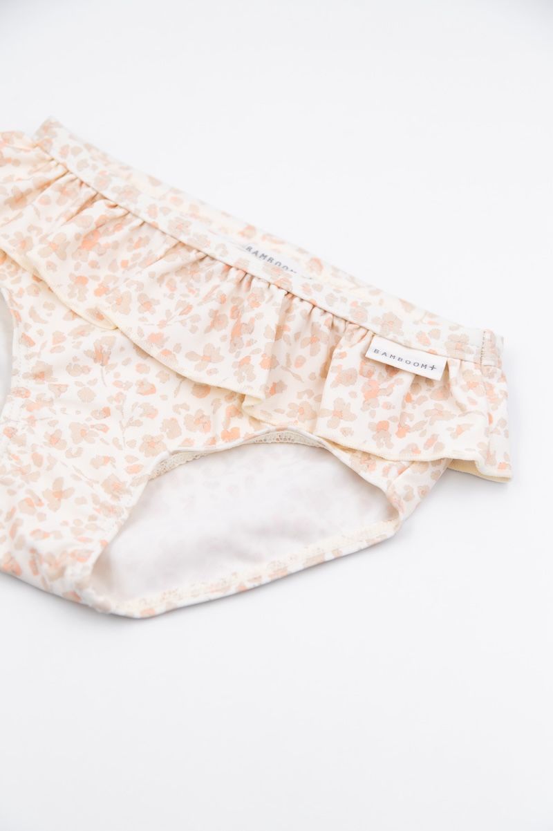particolare del volant slip bimba con volant colore rosa chiaro e petali di fiore