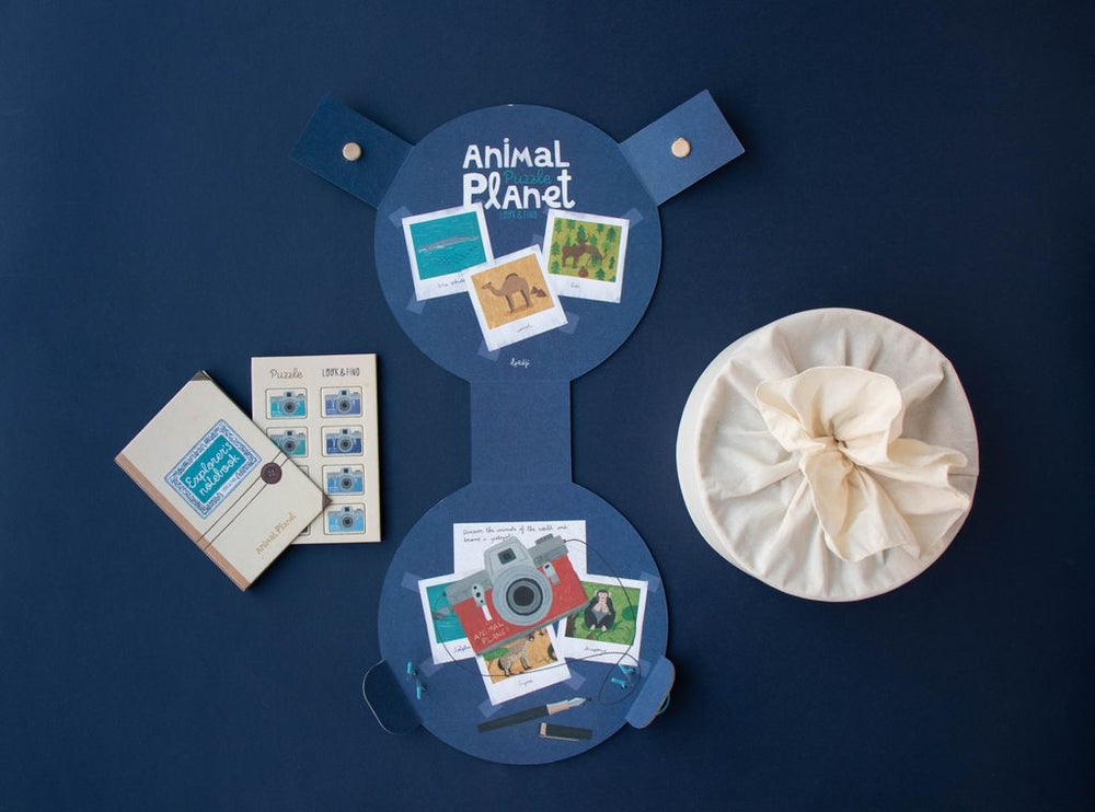 Interno della scatola del puzzle animal planet, taccuino dell'esploratore e tesserine segnaposto 