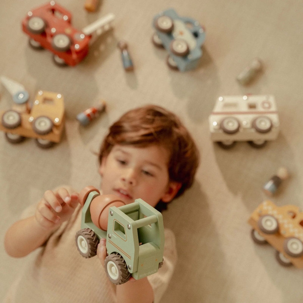 bimbo che tiene in mano la betoniera  e sullo sfondo le altre macchine da lavoro