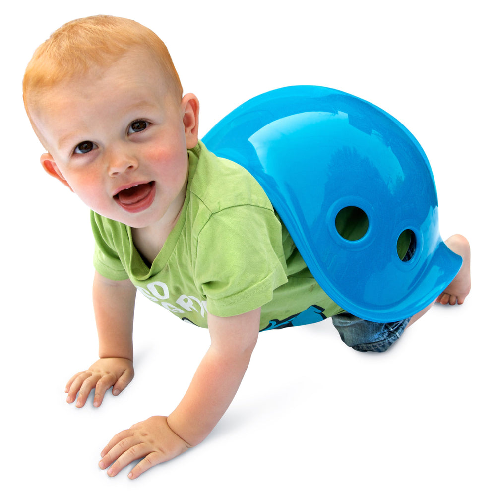 Bilibo-gioco innovativo e versatile, Moluk. In foto bambino che gioca con Bilibo e lo usa come un guscio imitando una tartaruga.