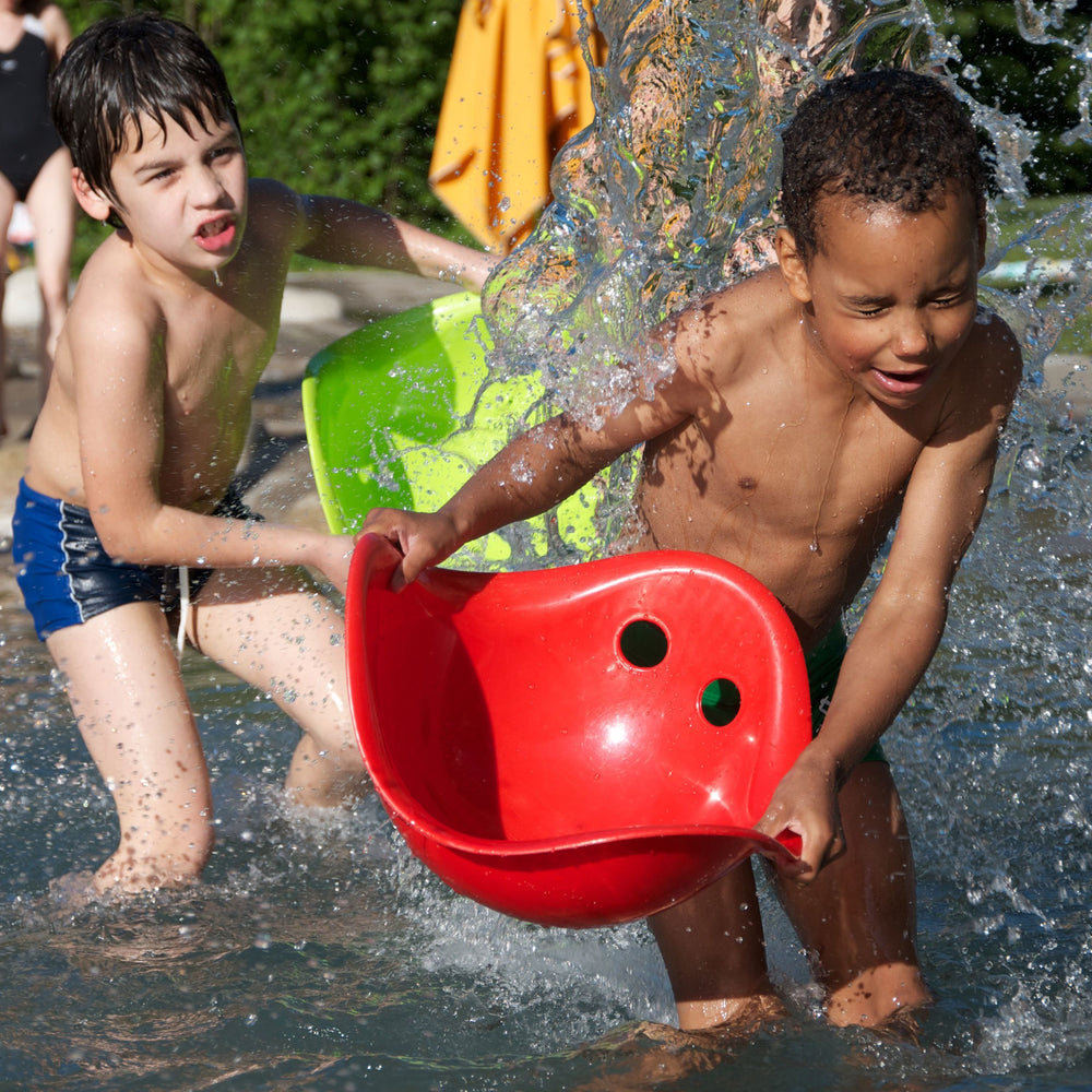 Bilibo-gioco innovativo e versatile, Moluk. In foto Bilibo rosso. Bambino che gioca con Bilibo utilizzandolo come recipiente per lanciare l'acqua.