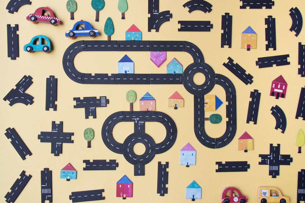 Pezzi di cartone per costruire strade case macchinine e alberelli