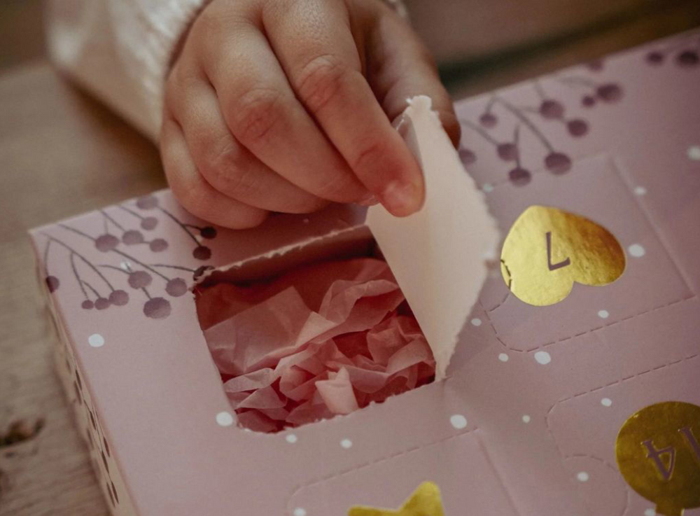 mani di bimba che scartano una casellina