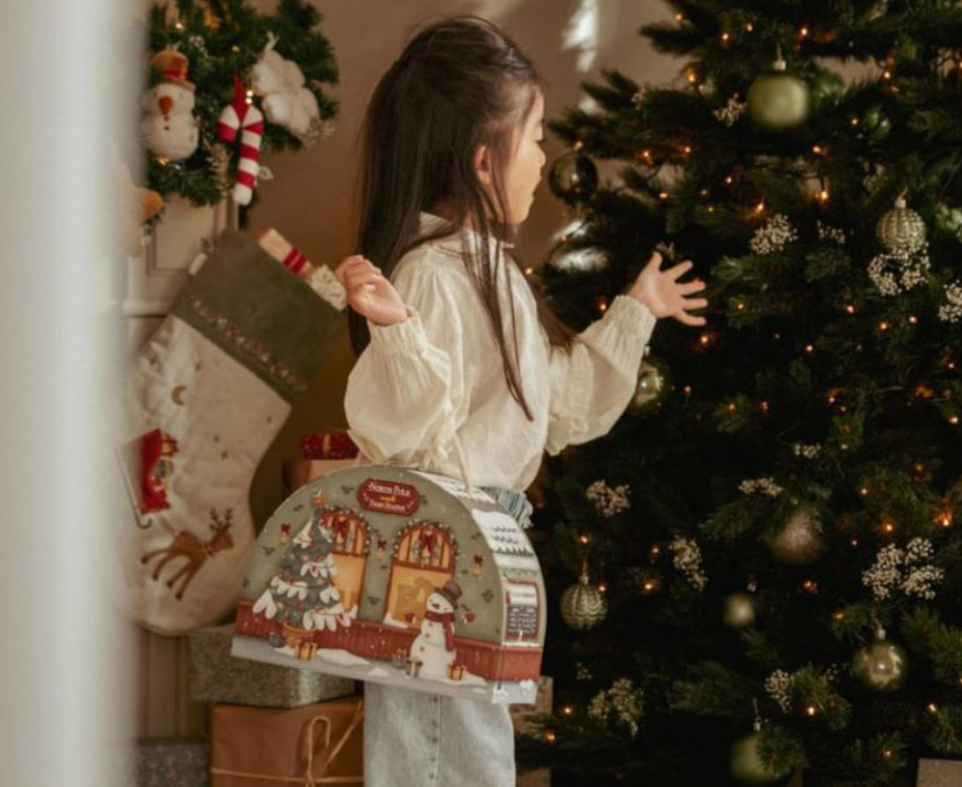 bimba che tiene in mano la valigetta del calendario dell'avvento