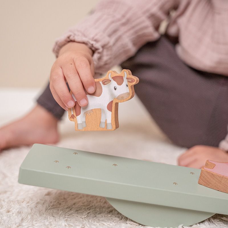 mano di bimba che appoggia la mucca sulla pedana
