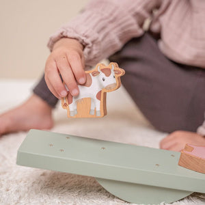 mano di bimba che appoggia la mucca sulla pedana
