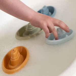 Barchette da bagno impilabili-stackable bath boats, Little Dutch. Mano di un bambino che gioca con le barchette nell'acqua