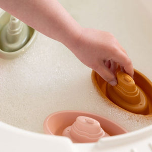 Barchette da bagno impilabili-stackable bath boats, Little Dutch. Mano di un bambino che gioca con le barchette in acqua
