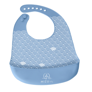 TAIKI BIB-bavaglino in silicone, Mizu Baby. Bavaglino azzurro con motivo ondulato stampato bianco e tasca frontale. Chiusura con asole in silicone regolabili 