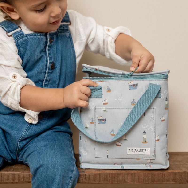 Borsa termica in tela, Little Dutch. In foto la versione con stampa Baia dei Marinai. Bambino che apre la zip della borsa 