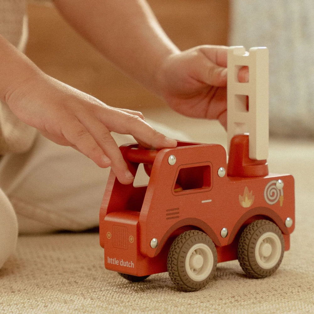 bimbo che gioca con il camion dei pompieri