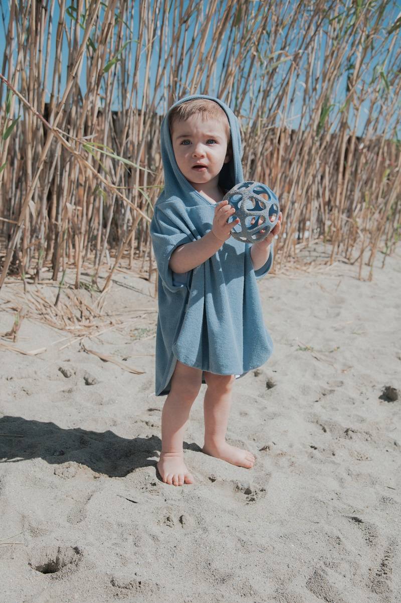 Massasggiagengive a pallina in silicone, Bamboom. In foto bambino sulla spiaggia che gioca con il dentaruolo blu