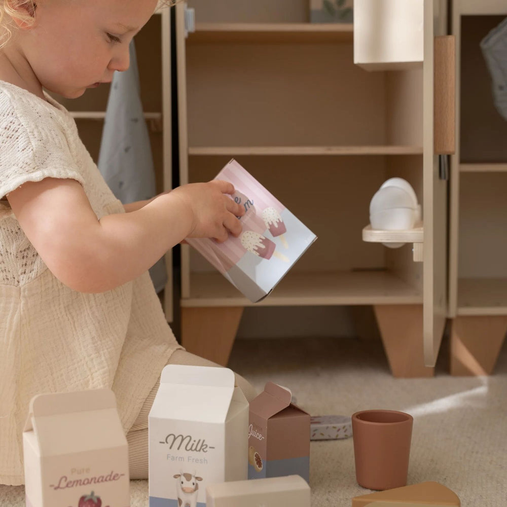 bimba che gioca con cartoni del cibo
