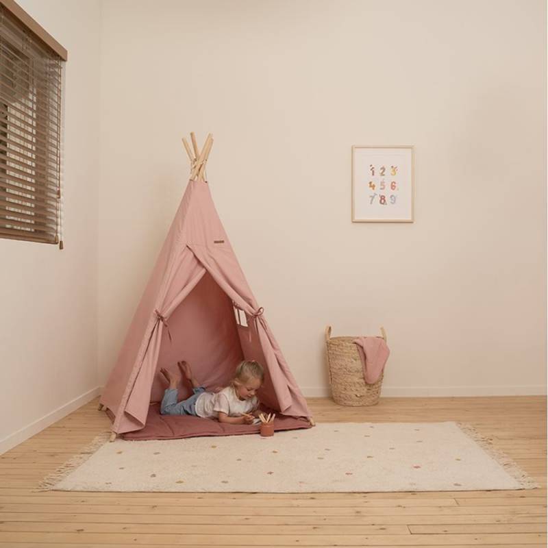 Foto ambientata di bambina che gioca nella tenda rosa