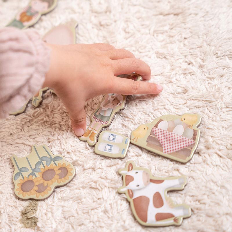 Immagine ambientata di bimba che sceglie tra i magneti, a tema fattoria, del puzzle magnetico di Little Dutch