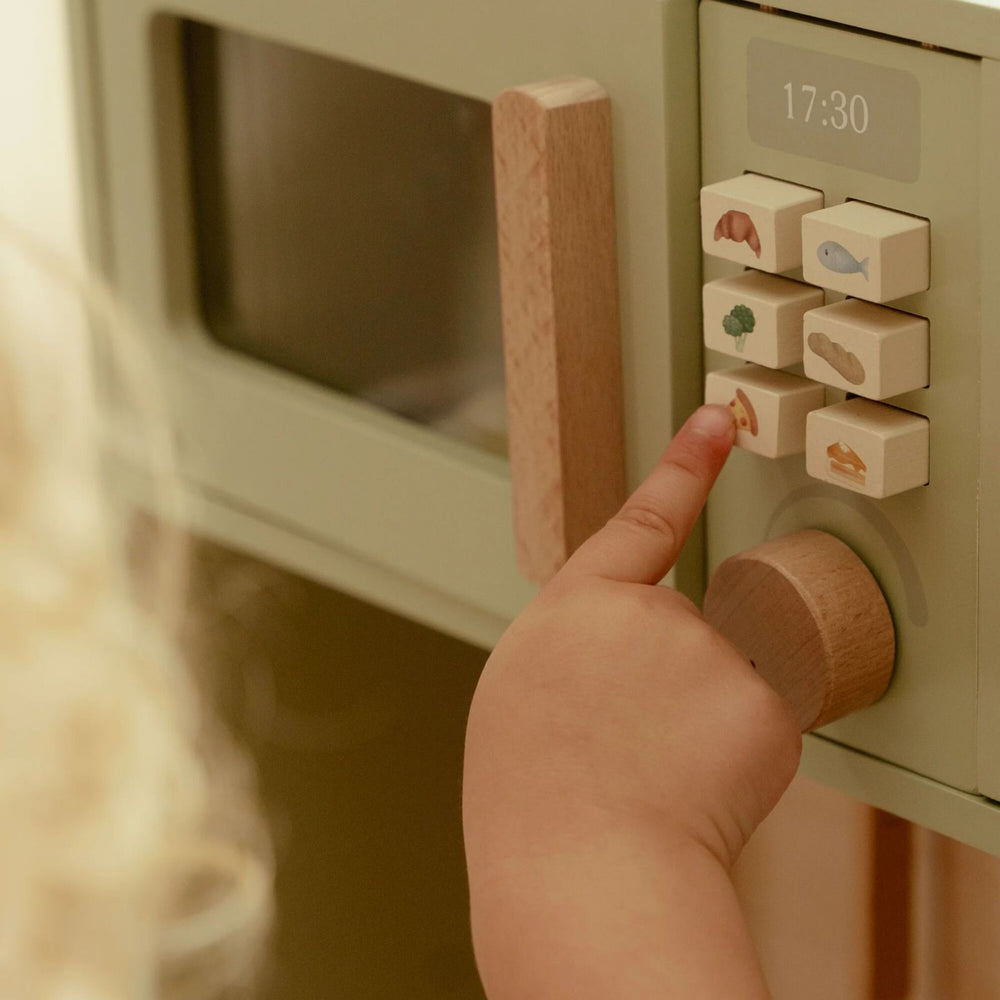 bimba che gioca con tasti del microonde