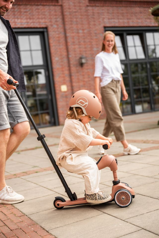 bimba seduta sul monopattino spinta dal papà nel colore mocha