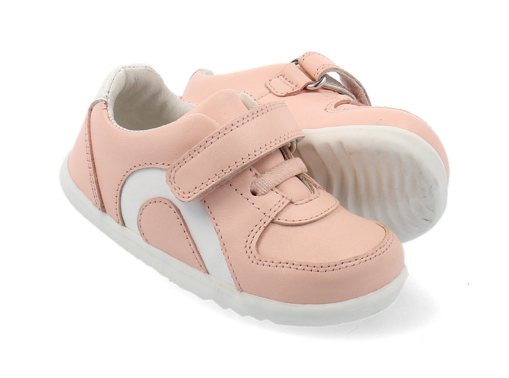 scarpa rosa con inserto sul lato bianco e suola bianca. uno strap ed elastico