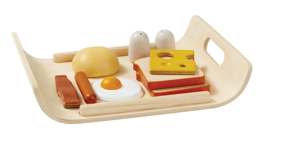 Set Colazione in legno , "Breakfast", Plan Toys. Vassoio rettangolare marrone chiaro, con manici, dalla forma arrotondata. Due toasts, una fetta di formaggio, un panino, un uovo al tegamino, un wurstel, un bacon, sale e pepe.