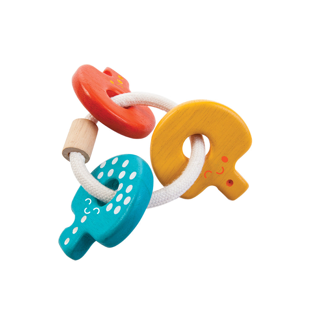 Sonaglio portachiavi in legno, "Key Rattle", Plan Toys. Sonaglio composto da 3 chiavi dai colori accesi: giallo, rosso e blu, tenuti insieme da un anello in corda bianco.