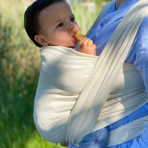 particolare del bambino legato davanti cn fascia bianca