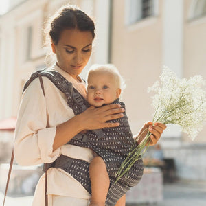 mamma che porta nel marsupio un bambino e