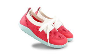 I-Walk Play Knit Guava/White, Bobux. Vista laterale delle scarpine con parte centrale in tessuto traforato rosso, laccetti bianchi, punta e tallone in sintetico rosso, suola gommata azzurra.