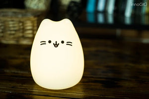Luce a led notturna in silicone MINI, InnoGIO. Lampada a forma di gattino in silicone bianco con occhi, musetto e baffi neri.. Lampada accesa