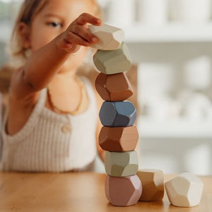 Stacking Stones, Pietre impilabili in legno, Little Dutch. Bambina che gioca con le pietre e prova a formare una torre