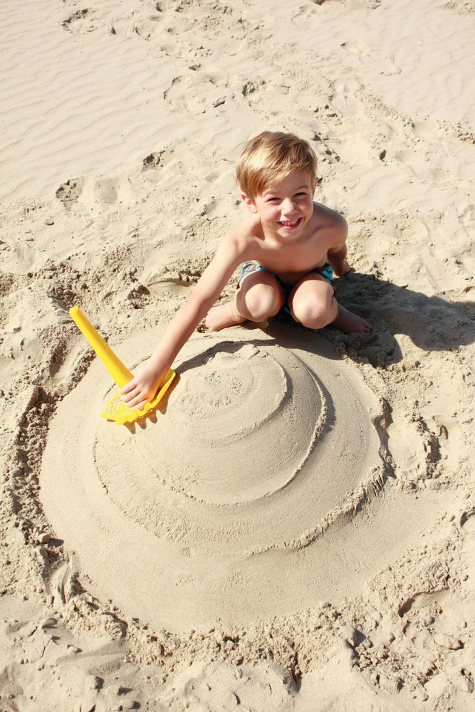 TRIPLET - Paletta Multifunzione da spiaggia, Quut. Bambino in spiaggia che gioca con Triplet a scavare nella sabbia