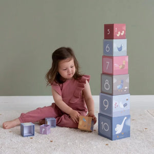 Blocchi impilabili in cartone a tema Little Goose, Little Dutch. Bambina seduta sul tappeto che gioca ad impilare i blocchi