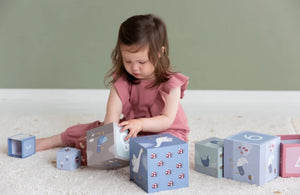 Blocchi impilabili in cartone a tema Little Goose, Little Dutch. Bambina seduta sul tappeto che gioca con un blocco