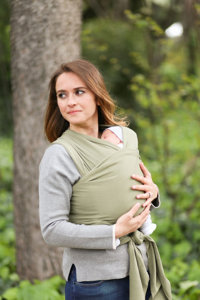 una mamma che porta un bimbo in fascia