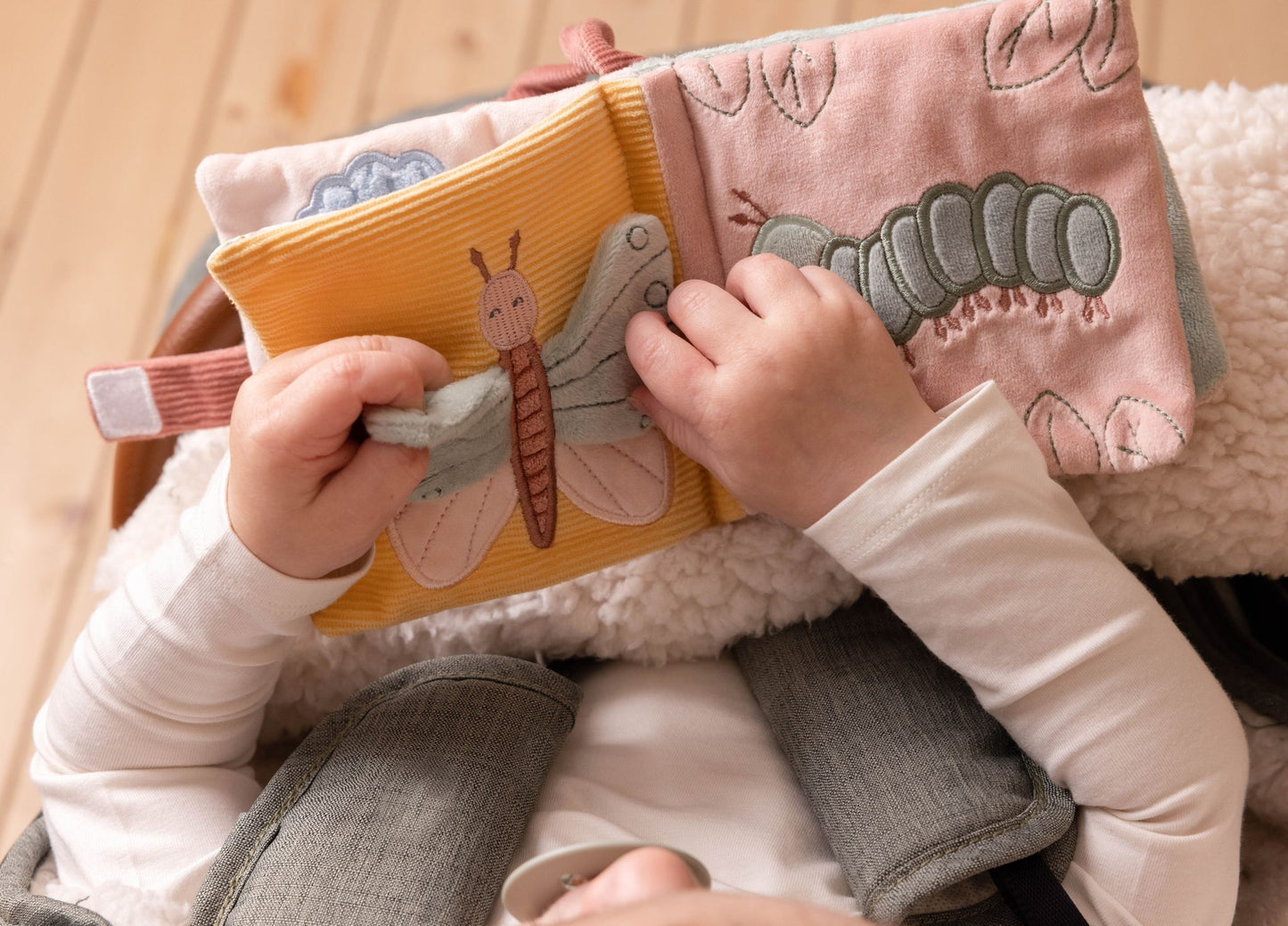 bimbo che gioca con libro morbido collezione fairy garden