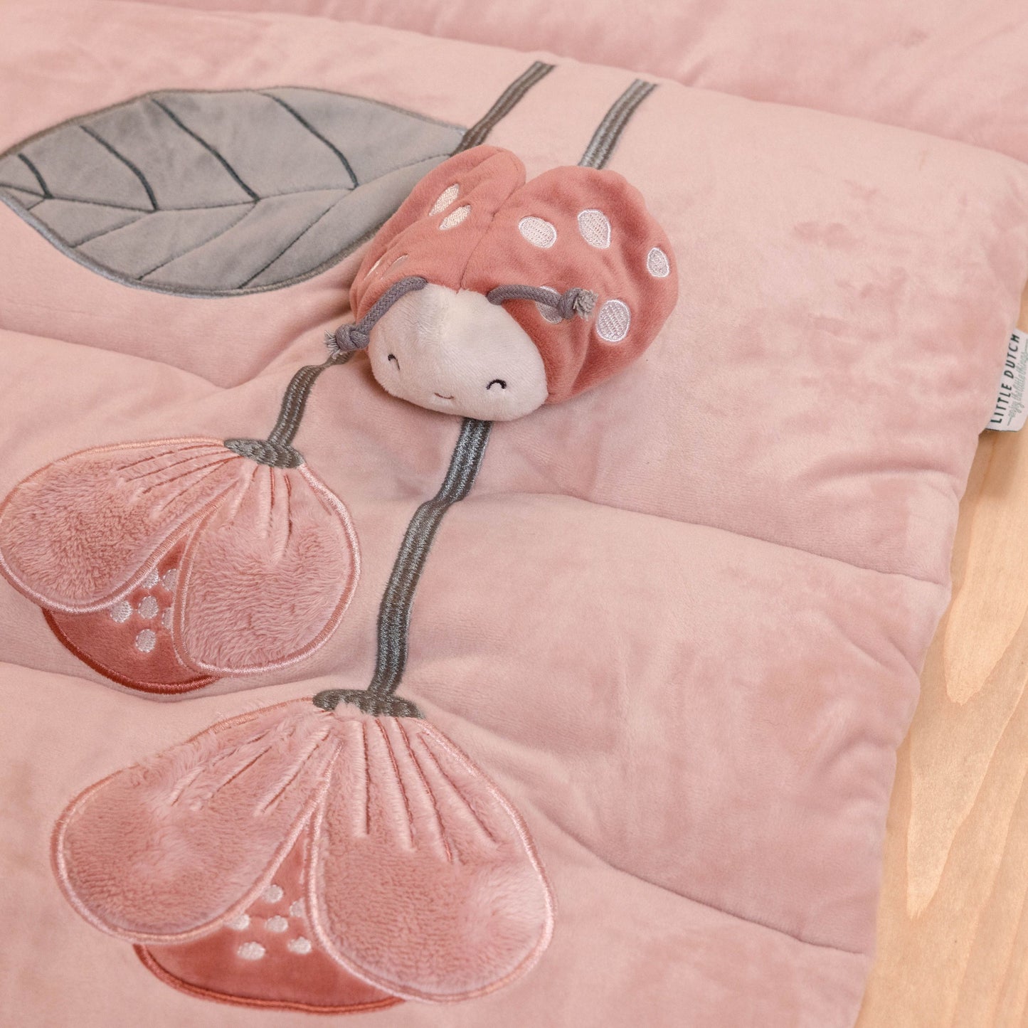Tappeto morbido PlayPen Mat a tema Fiori e Farfalle, Little Dutch. Vista sul particolare dei fiori ricamati sul tappeto con piccola coccinella morbida cucita sopra