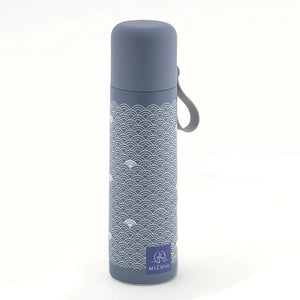 Thermos Yume 500 ml, Mizu Baby. Contenitore termico blu con laccio in silicone nella parte alta del tappo, per facilitare la presa e il trasporto. Thermos con sfondo blu e onde bianche stampate sopra. Tappo blu. Laccetto in silicone grigio.